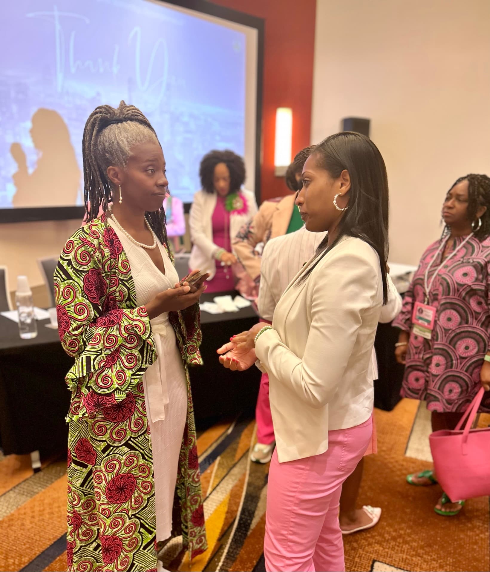 Althea in close conversation with an attendee at a past gathering